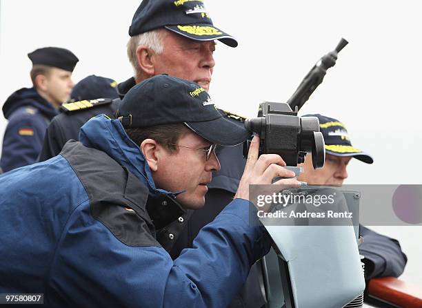 German Defense Minister Karl-Theodor zu Guttenberg looks through a telescope during his inaugural visit aboard the FGS Mecklenburg Vorpommern Navy...