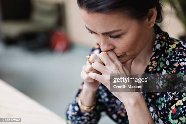 close-up of tired thoughtful businesswoman with arms crossed at office - tension stock pictures, royalty-free photos & images