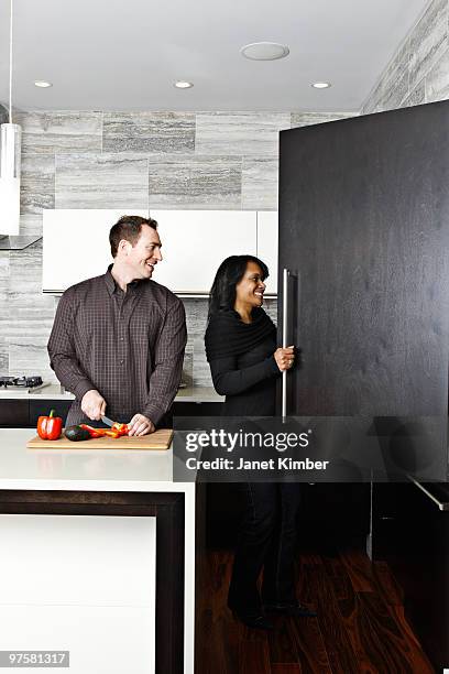 inter-racial couple cooking together in kitchen. - dartmouth nova scotia stock-fotos und bilder