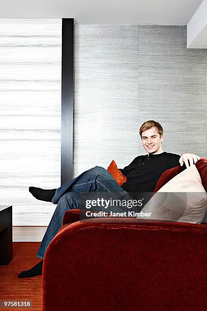 condo lifestyle: young man relaxing on sofa. - dartmouth nova scotia stock-fotos und bilder