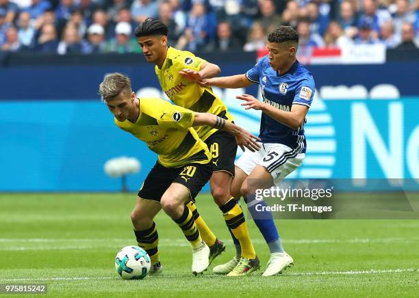 Maximilian Philipp of Dortmund and Mahmoud Dahoud of Dortmund and Amine Harit of Schalke battle for the ball during the Bundesliga match between FC...