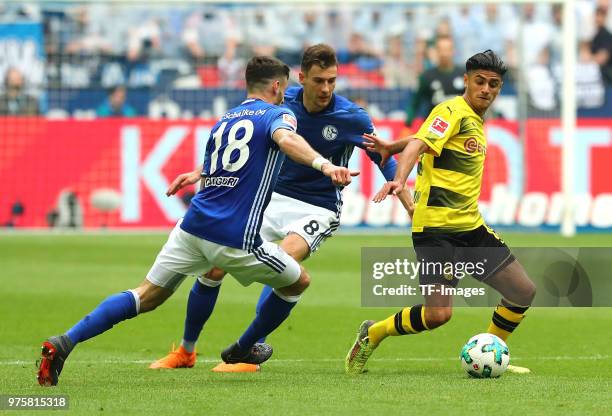 Daniel Caligiuri of Schalke and Leon Goretzka of Schalke and Mahmoud Dahoud of Dortmund battle for the ball during the Bundesliga match between FC...