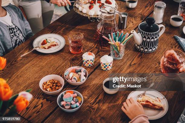 high angle view of family enjoying meal at table during birthday party - snack table stock pictures, royalty-free photos & images