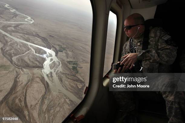 Army chaplain Carl Subler flies over the Argandab River while moving between bases to celebrate Catholic Mass for soldiers on March 9, 2010 in...