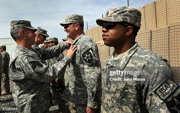 International Security Force Afghanistan CSM Michael Hall pins a combat action badge on the chest of U.S. Army Chaplain Cpt. Kevin Burton during an...