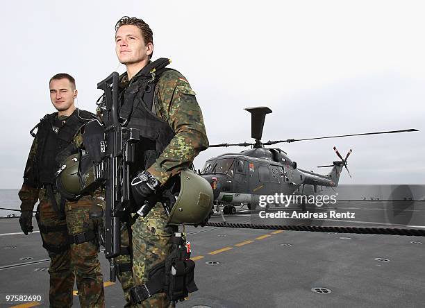 The boarding team of the German navy stands near a helicopter during German Defense Minister zu Guttenberg's inaugural visit aboard the FGS...