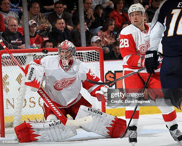 Brian Rafalski of the Detroit Red Wings looks for the flying puck as teammate Jimmy Howard makes a blocker save during an NHL game against the...