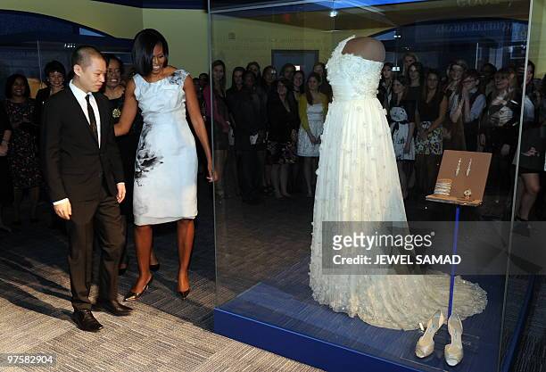 First Lady Michelle Obama and designer Jason Wu look at a display of her inaugural gown, jewelries and shoes at the Smithsonian�s National Museum of...