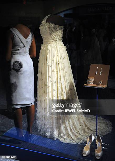 First Lady Michelle Obama is reflected on a display of her inaugural gown, jewelries and shoes at the Smithsonian�s National Museum of American...