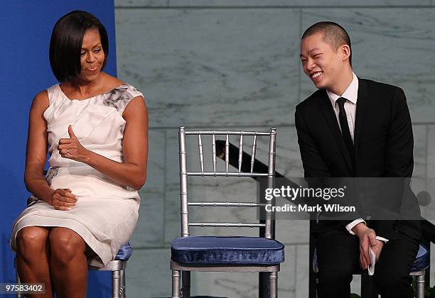 First lady Michelle Obama gives inaugural dress designer Jason Wu a thumbs up during an event where she donated her inaugural gown to the Smithsonian...