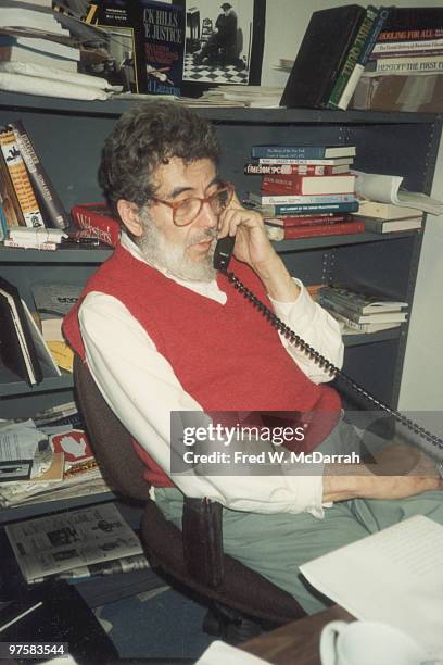 American journalist and music critic Nat Hentoff makes a telephone call at his desk in the office of the Village Voice newspaper, New York, New York,...