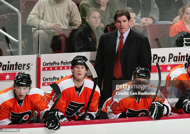 Ryan Parent, Chris Pronger, Head Coach Peter Laviolette and Darroll Powe of the Philadelphia Flyers all watch the play develop from their bench...