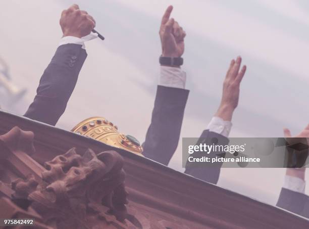 May 2018, Germany, Frankfurt am Main: Players and the coach of Eintracht Frankfurt greet the fans on the Roemerberg while standing on the balcony of...