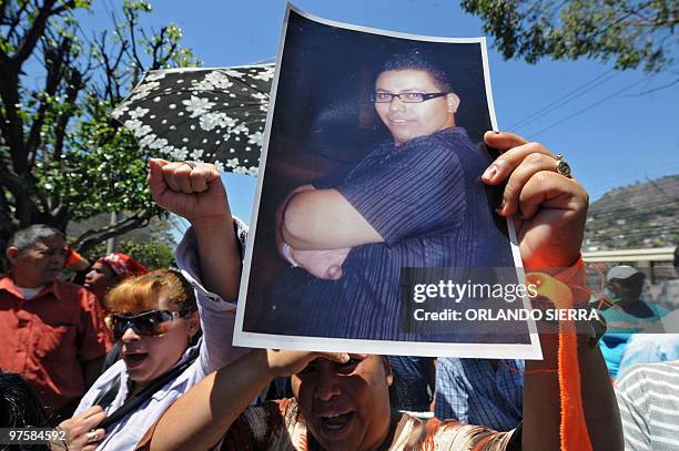 Family members and friends of murdered Honduran student of journalism, Joseph Ochoa, show pictures of him during a protest in front of the US embassy...