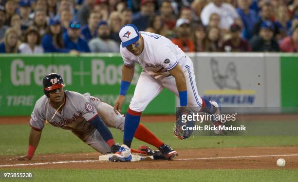 Toronto Blue Jays second baseman Yangervis Solarte mishandles the throw as Washington Nationals shortstop Wilmer Difo slides into 3rd late in the...