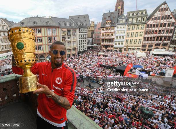 May 2018, Germany, Frankfurt am Main: Eintracht Frankfurt's Kevin-Prince Boateng carries the cup while standing on the balcony of the Roemer . The...