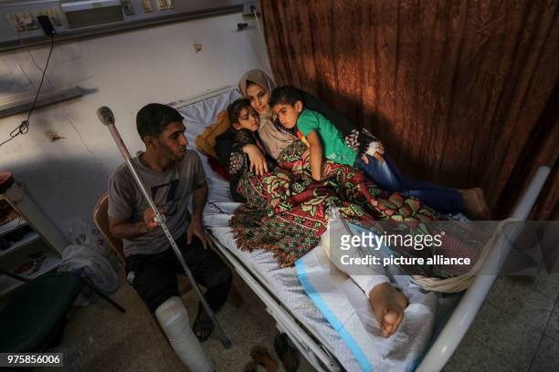 Dpatop - Palestinian woman Asma Abu Daqah and her husband Mohammed Abu Daqah lie inside a hospital with their daughter Lian and their son Omar after...