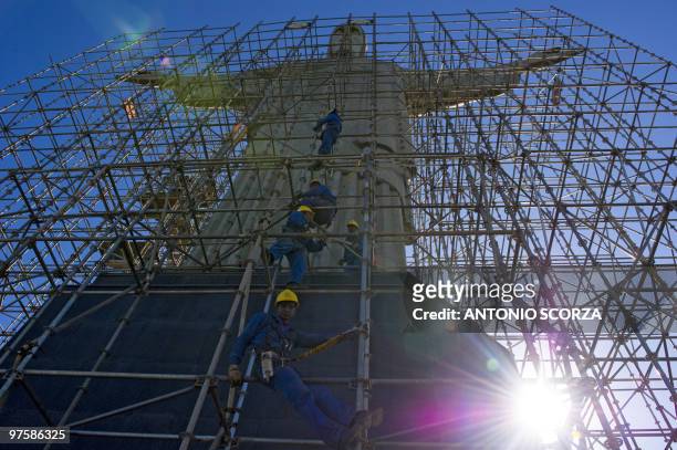 Workers climb the scaffoldings surrounding the Christ the Redeemer statue during a cleaning operation, on March 9, 2010 in Rio de Janeiro, Brazil....