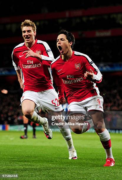 Samir Nasri of Arsenal celebrates with teammate Nicklas Bendtner after scoring his team's third goal during the UEFA Champions League round of 16...