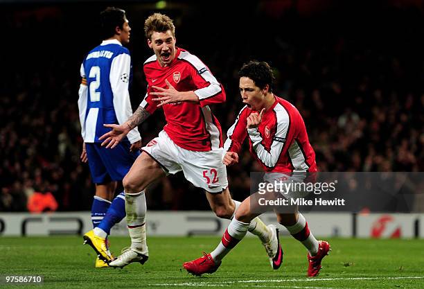 Samir Nasri of Arsenal celebrates with teammate Nicklas Bendtner after scoring his team's third goal during the UEFA Champions League round of 16...