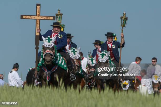 May 2018, Germany, Bad Koetzing: Participants of the Whit Monday procession ride their horses while carrying crosses and torches. This event,...