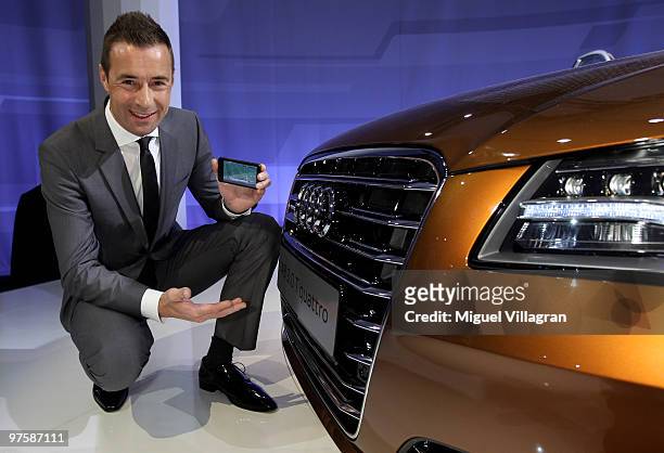 Kai Pflaume poses next to an Audi A8 while watching soccer on his cell phone during the presentation of the new Audi A8 on March 9, 2010 in Munich,...