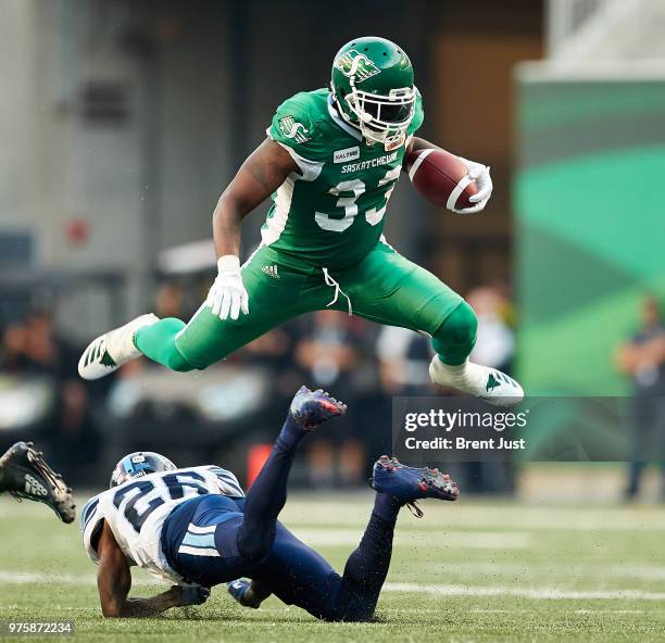 Jerome Messam of the Saskatchewan Roughriders hurdles over Cassius Vaughn of the Toronto Argonauts during a run play in the first half of the game...