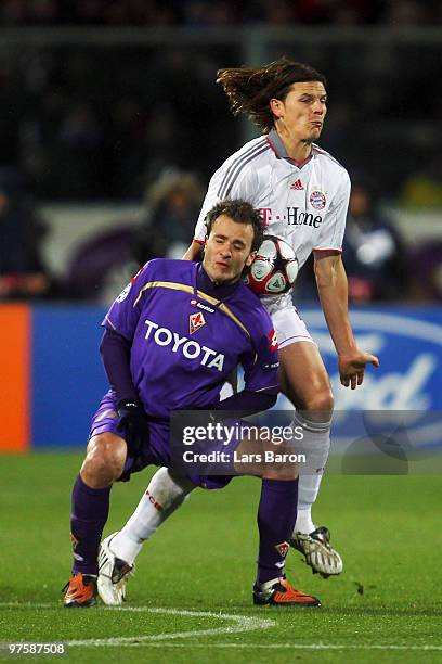 Alberto Gilardino of Florence is challenged by Daniel van Buyten of Muenchen during the UEFA Champions League round of sixteen, second leg match...