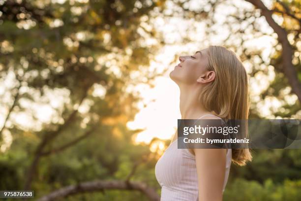mujer respirar fresco en bosque - inhaling fotografías e imágenes de stock