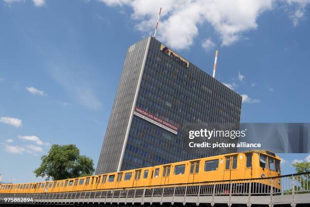 May 2018, Germany, Berlin: A U-Bahn train drives past the highrise building of the Postbank near Moeckernbruecke station in the direction of the...