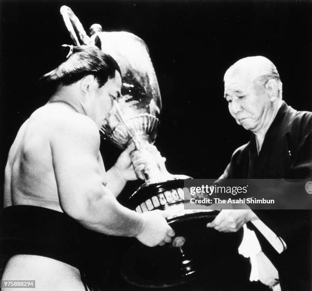 Yokozuna Chiyonofuji receives the trophy from Japan Sumo Association President Futagoyama after winning the tournament on day fifteen of the Grand...