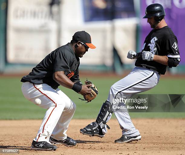 Juan Uribe of the San Francisco Giants fails to catch the ball as Paul Konerko of the Chicago White Sox is safe at second base after hitting a double...