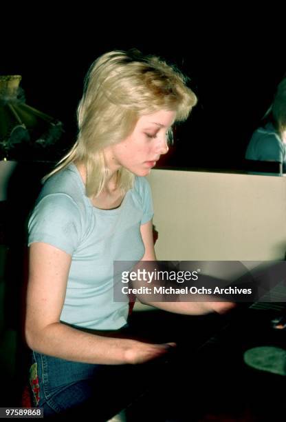 Singer Cherie Currie of the rock band 'The Runaways' plays the piano at her family's home in Encino in Los Angeles in December of 1976.