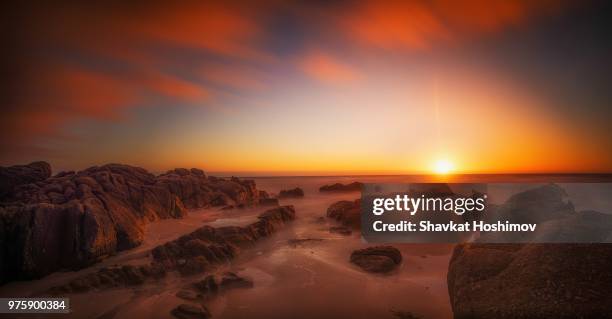 sunrise over rocky shore - shavkat stock-fotos und bilder