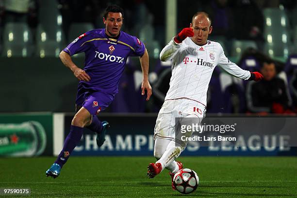 Mario Bolatti of Florence challenges Arjen Robben of Muenchen during the UEFA Champions League round of sixteen, second leg match between AFC...