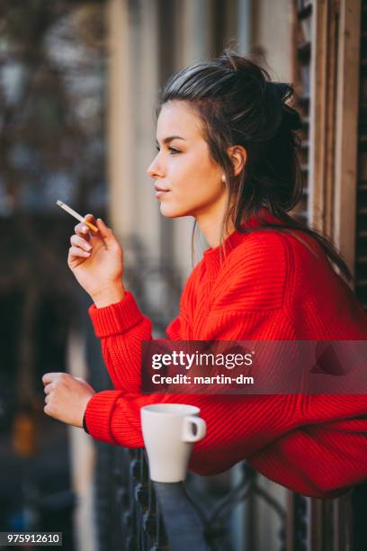 ontspannen vrouw roken op het terras - jalousie stockfoto's en -beelden