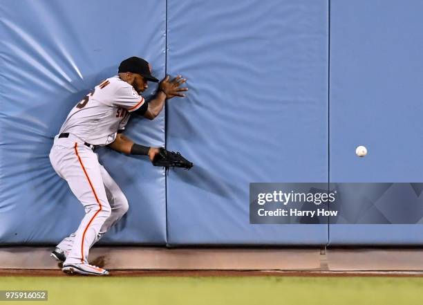 Austin Jackson of the San Francisco Giants collides with the centerfield wall after dropping a ball hit by Yasmani Grandal of the Los Angeles Dodgers...