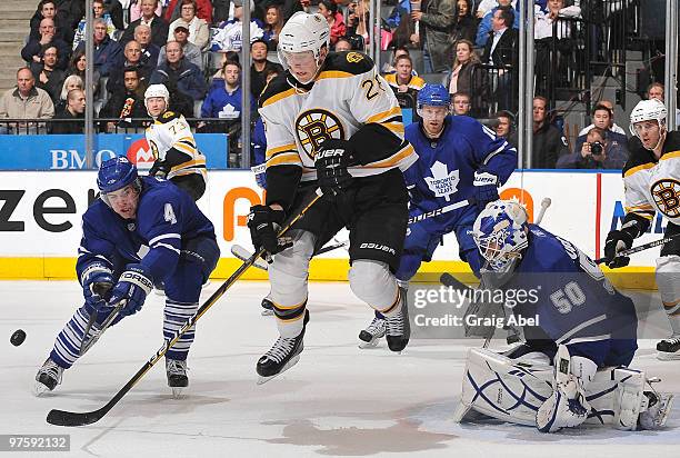 Jeff Finger of the Toronto Maple Leafs battles for the puck with Blake Wheeler of the Boston Bruins in front of goalie Jonas Gustavsson during game...