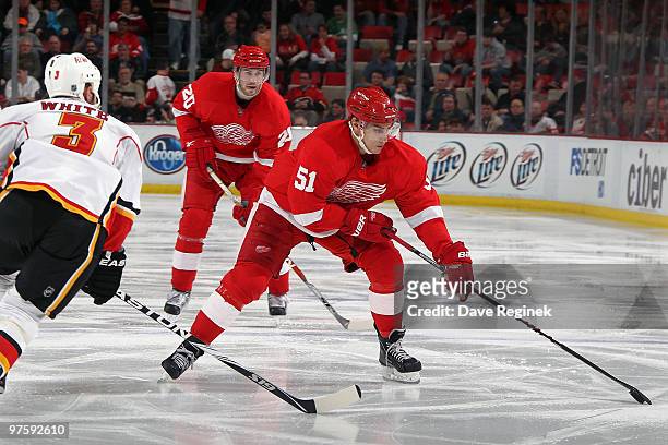 Valtteri Filppula of the Detroit Red Wings skates with the puck around the defense of Ian White of the Calgary Flames during an NHL game at Joe Louis...