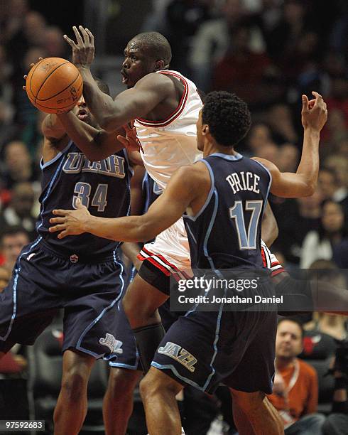 Loul Deng of the Chicago Bulls loses control of the ball when he is fouled by C.J. Miles of the Utah Jazz as he tries to drive between Miles and...