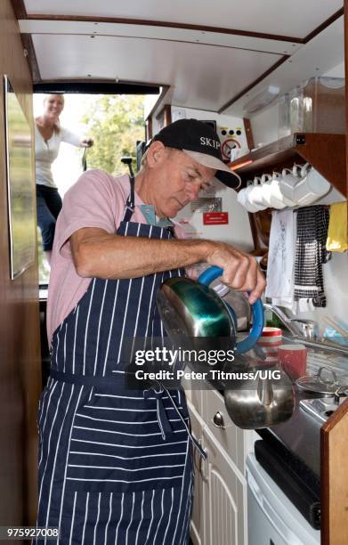 man making tea in the galley of a narrow boat - narrow kitchen stock pictures, royalty-free photos & images