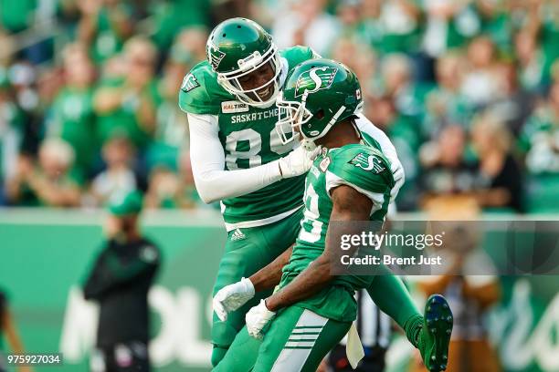 Duron Carter celebrates with Caleb Holley of the Saskatchewan Roughriders after long catch to set up a touchdown in the game between the Toronto...