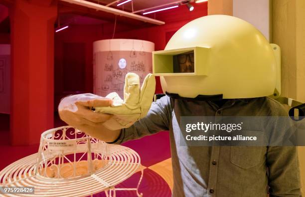 May 2018, Germany, Hamburg: A visitor tries to throw a glove at a target, while wearing a helmet that simulates visual impairment. The interactive...