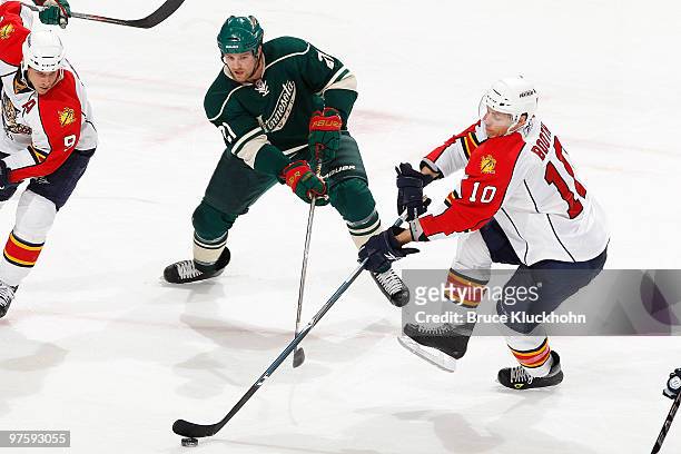 David Booth of the Florida Panthers skates with the puck while Kyle Brodziak of the Minnesota Wild defends during the game at the Xcel Energy Center...