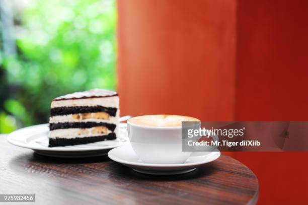 cup of capuchino coffee with chocolate banana cake - dii stock-fotos und bilder