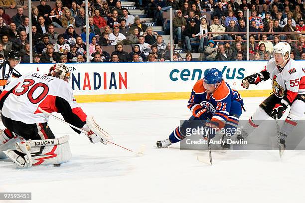 Mike Comrie of the Edmonton Oilers is interfered with during a breakaway by Brian Lee of the Ottawa Senators, after which Comrie was awarded a...