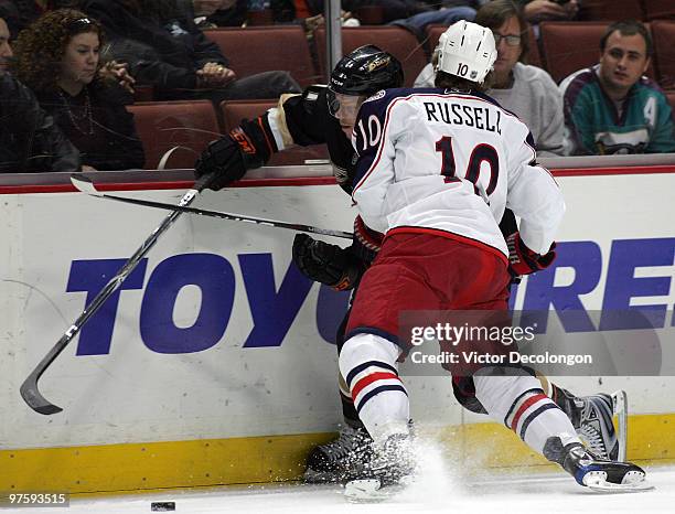 Kris Russell of the Columbus Blue Jackets checks Saku Koivu of the Anaheim Ducks in the first period during their NHL game at the Honda Center on...