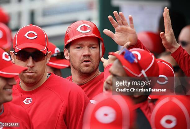 Scott Rolen of the Cincinnati Reds celebrates with teammates after scoring during the MLB spring training game against the Kansas City Royals at...