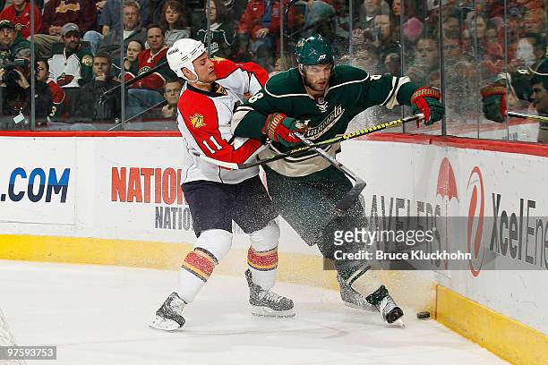 Brent Burns of the Minnesota Wild and Gregory Campbell of the Florida Panthers battle for a loose puck during the game at the Xcel Energy Center on...