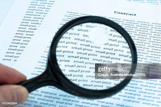reading the small print of a contract. - petits caractères photos et images de collection